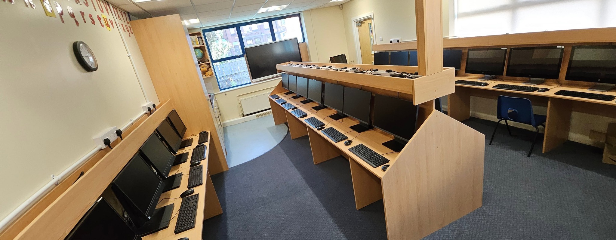 A completed school IT suite with custom-built furniture, computer workstations, electrical power and data infrastructure